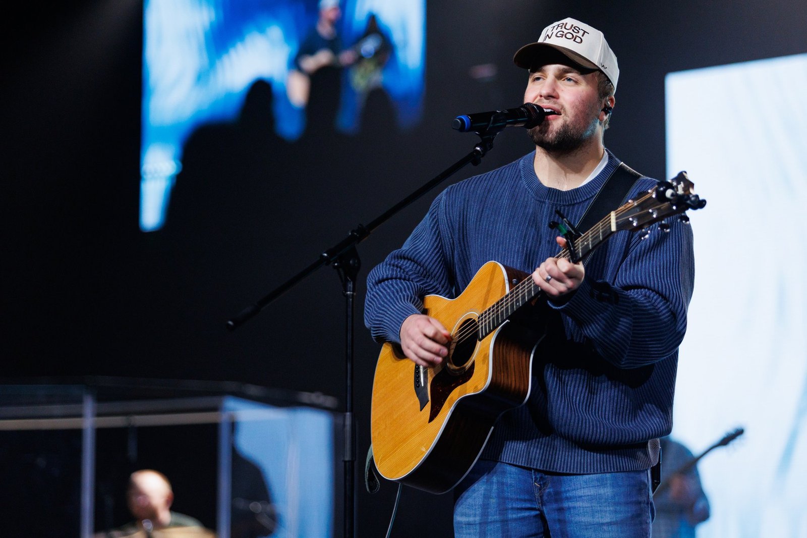 A musician sings while playing an acoustic guitar