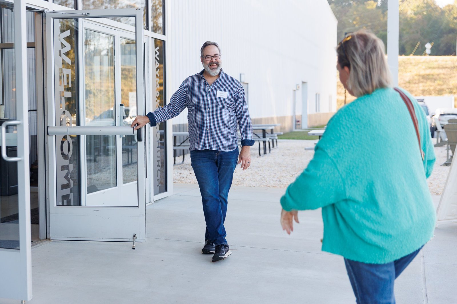 A greeter welcomes a visitor at the church entrance