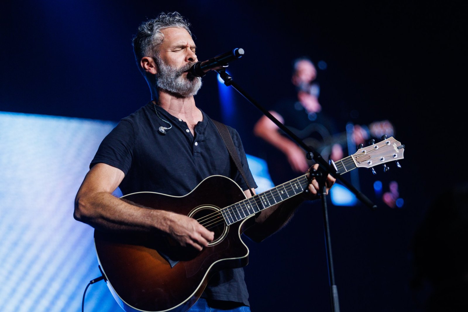 A guitarist sings during a worship service