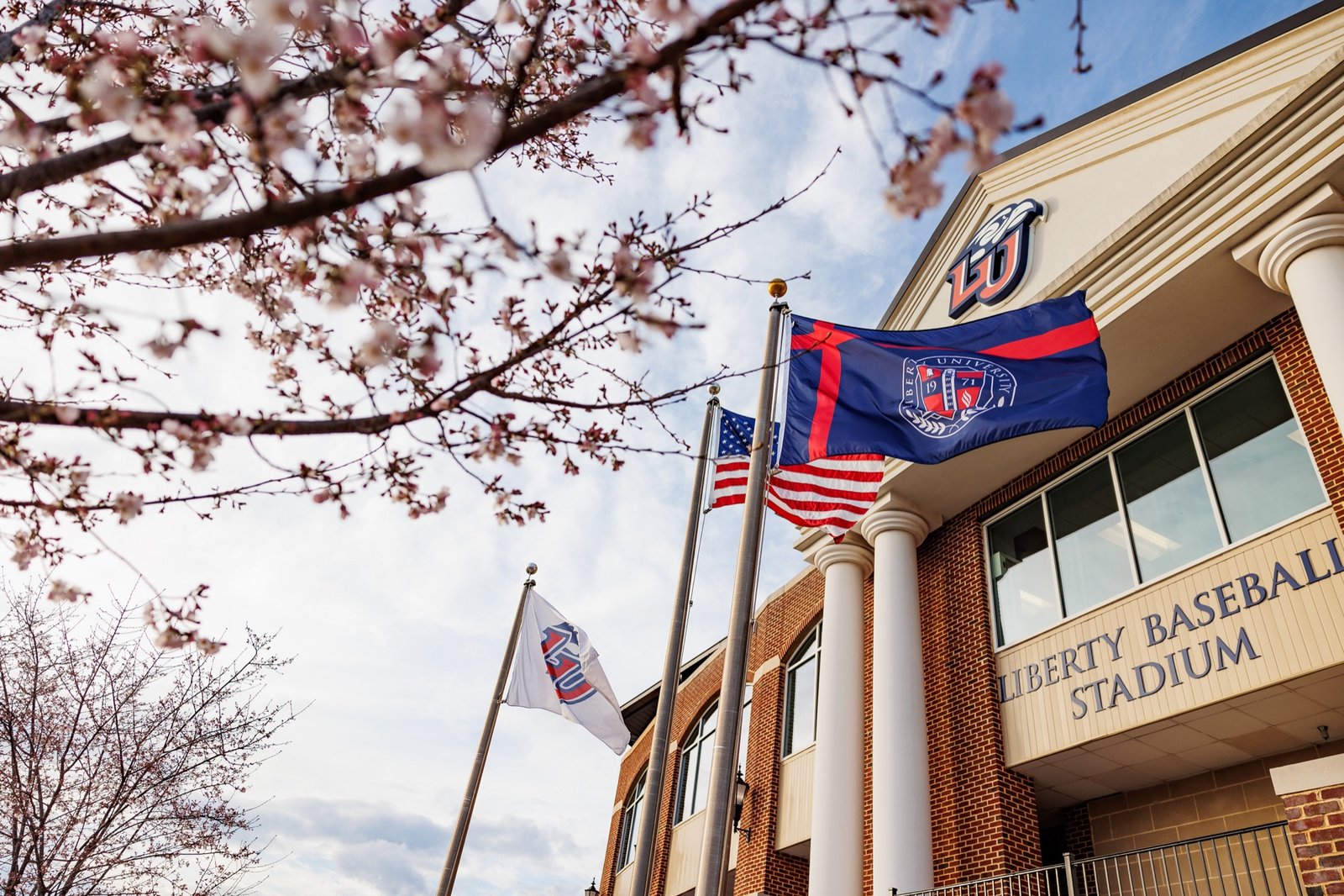 Spring blossoms frame the entrance to Liberty Baseball Stadium