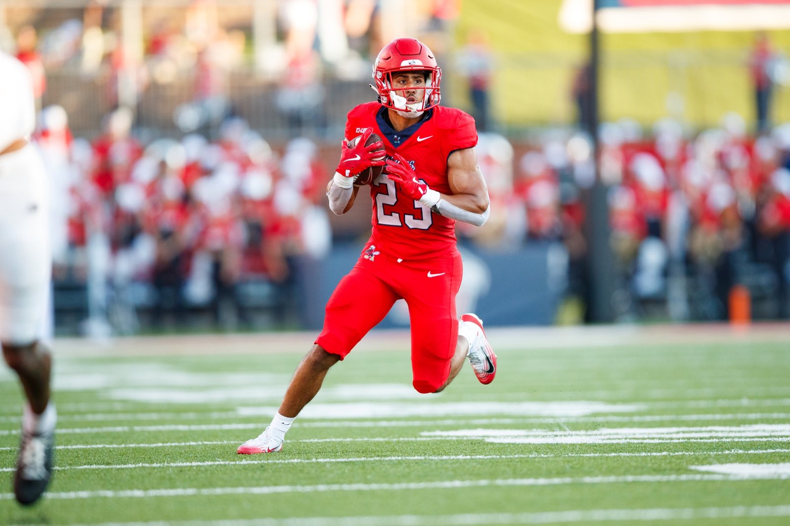 A Liberty football player runs with the ball