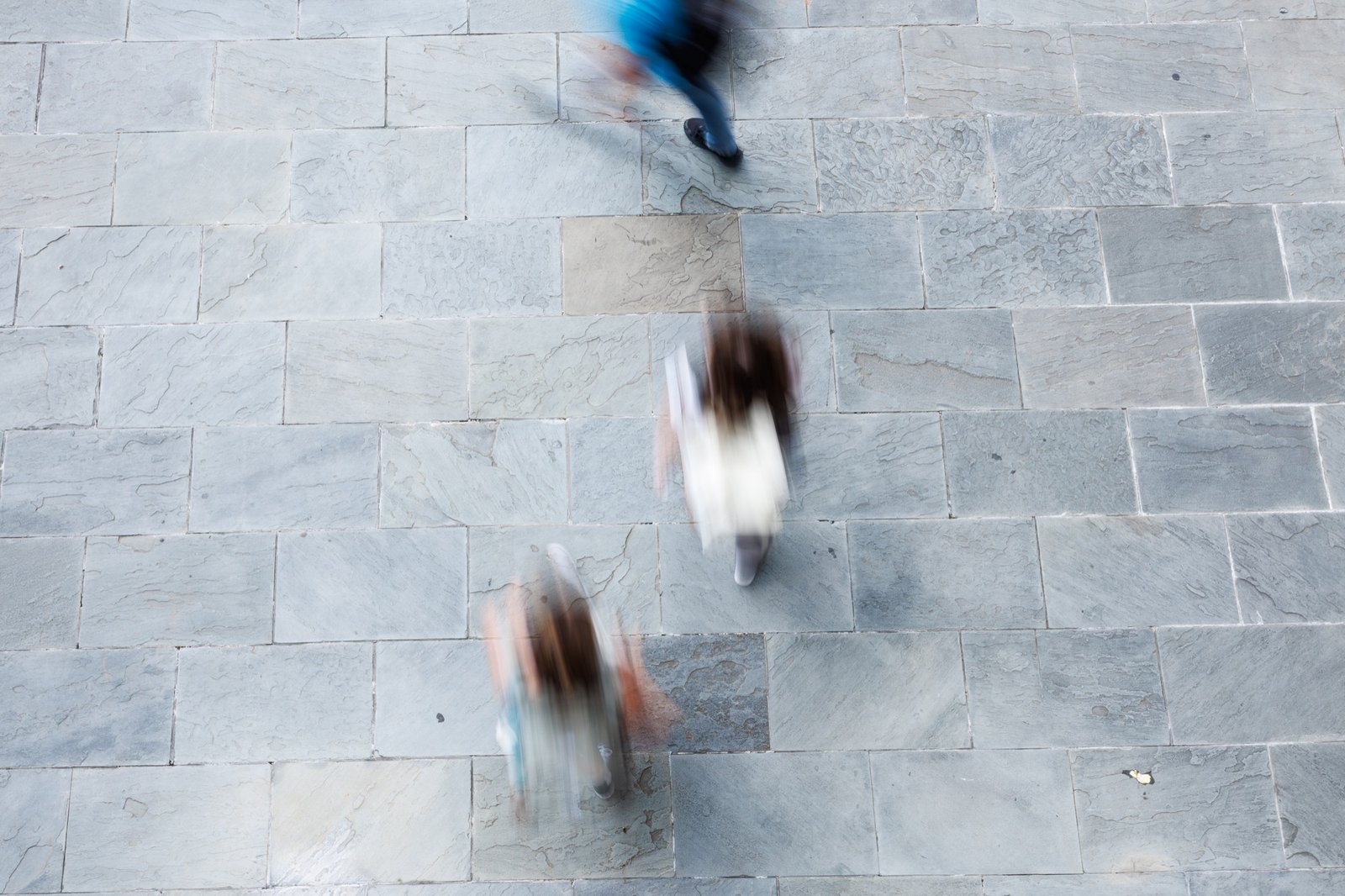 An overhead view of people moving across a stone walkway