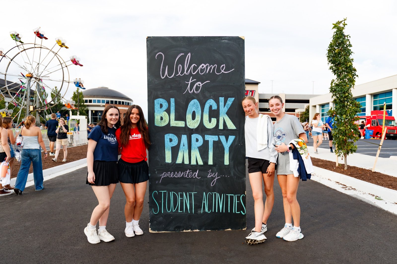 Students pose beside the Block Party welcome sign