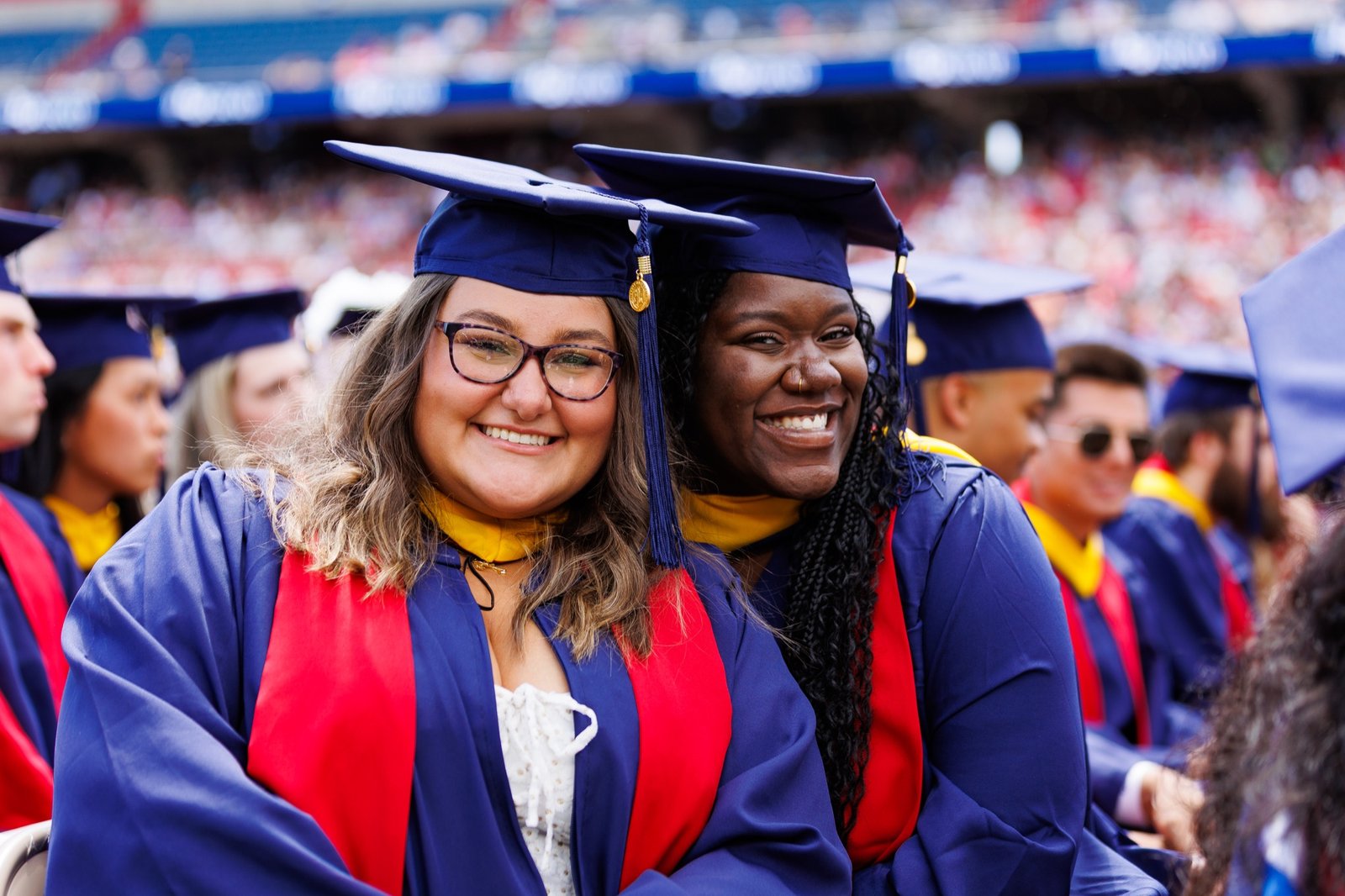 Two graduates celebrate together at commencement