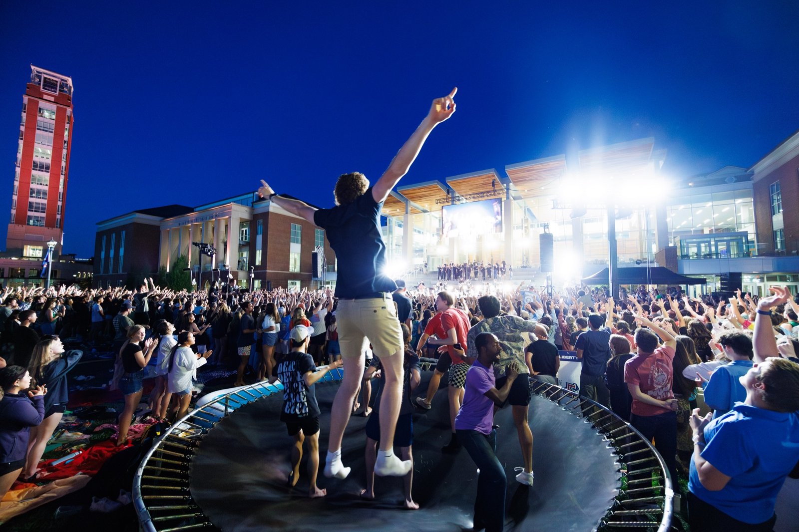A worshipper stands above the crowd at Campus Community on the Lawn